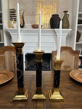 Three brass and black marble look tapered candle stick holders.